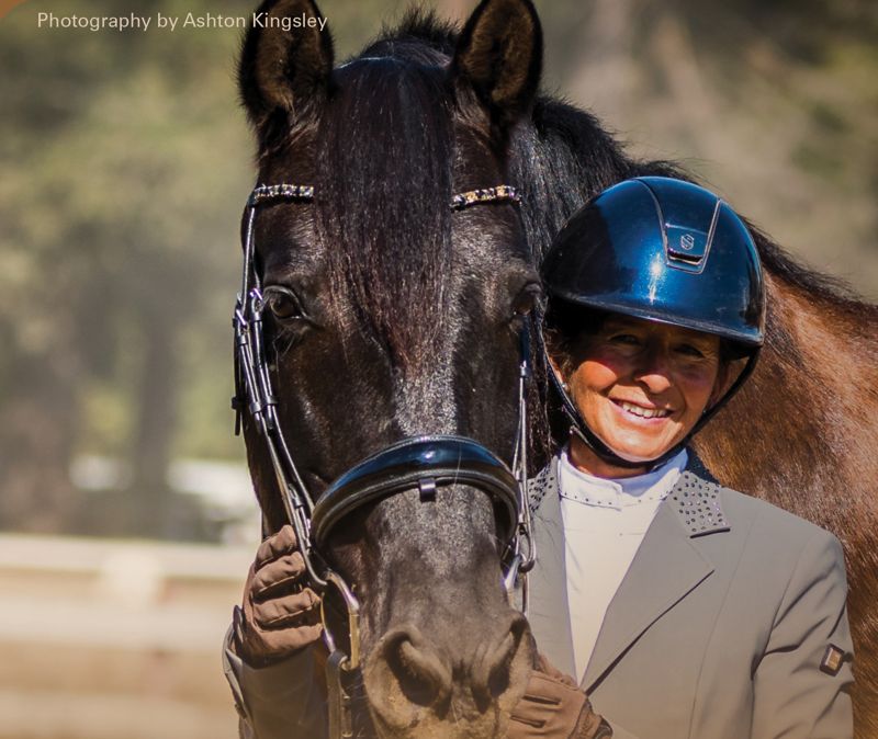 Agi Yother smiling alongside a horse